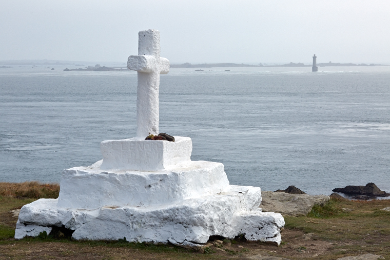 On the cliff of Ouessant, the Pen-ar-Lan cross watches over the lost sailors, facing the Créac’h lighthouse which stands in the mist.