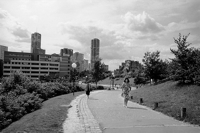 En arrière-plan, on peut voir les tours d'habitation où les gens partent de chez eux. Paris, la Défense, août 1987.