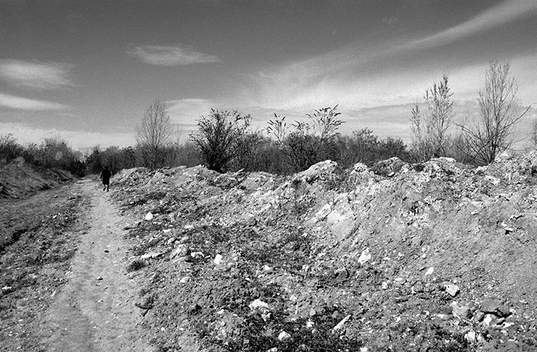Au loin, un homme se déplace d'un pas ferme sur un terrain vague, Rueil-Malmaison, avril 1987.