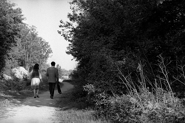 Un couple se promène paisiblement le long d’un chemin bordé de nature, Rueil-Malmaison, avril 1987