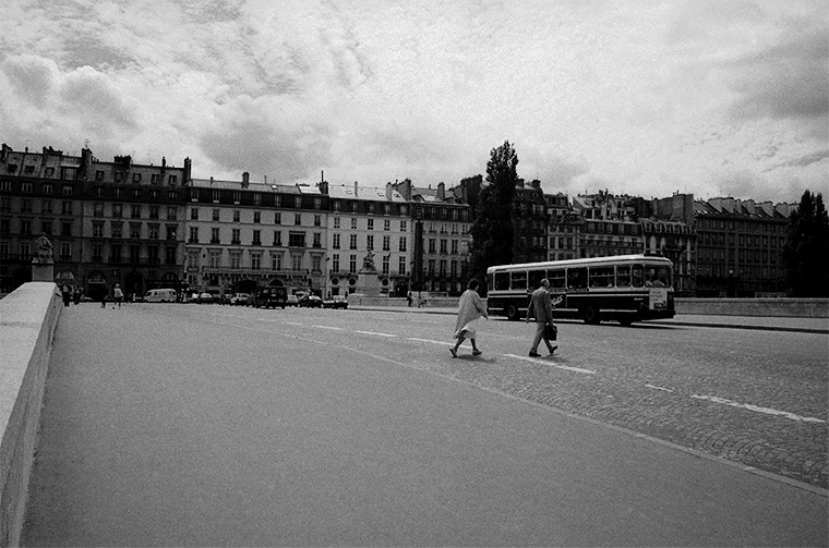 Scène urbaine : un couple traverse un pont tandis qu’un bus passe, Paris, été 1987.