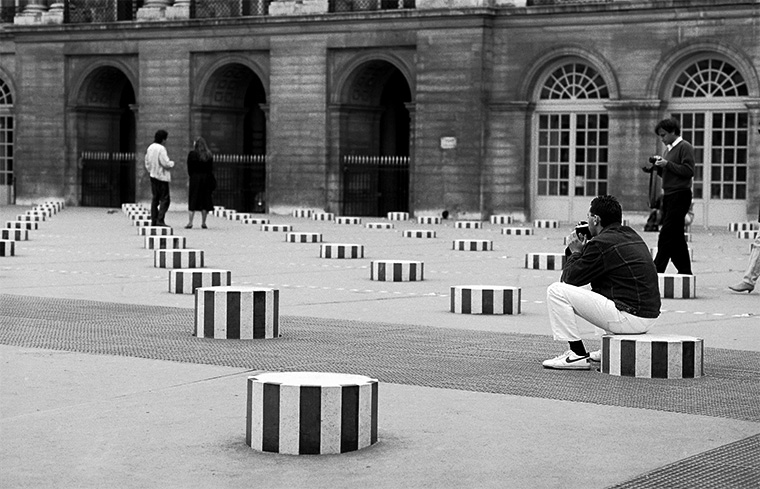 L’instant décisif : un photographe en quête d’image sur les colonnes de Buren, Palais-Royal, Paris, juin 1987.