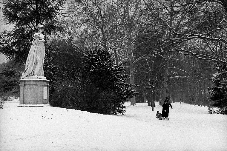 Sous le regard immobile de Joséphine, un couple et leur enfant tirent un traîneau dans la neige de la Malmaison, Rueil-Malmaison, janvier 1983.